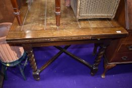 A traditional oak extending kitchen table on barley twist legs