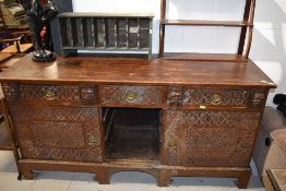 An antique sideboard having continental possibly French influence decorated with Norman style carved