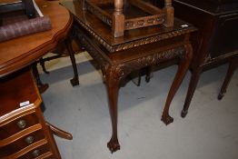 A traditional mahogany effect side table on scroll legs with ball and claw feet, glass top,