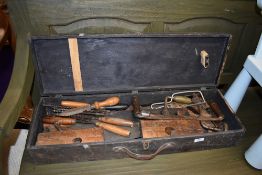 A selection of woodworkers tools including large draw knife and beech wood moulding planes