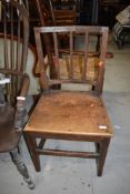 A 19tbh Century oak solid seat and rail back dining chair