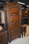 An early 20th Century oak hall robe, having panelled doors and carved detail