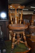 A Victorian sewing or craft chair having turned oak frame work adjustable seat with cast and glass