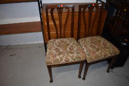 A pair of early 20th Century oak dining chairs having shaped slat backs and stuffed seats, real nice