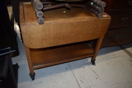 A mid 20th Century golden oak tea trolley in the Arts and Crafts style, having recessed top, makers