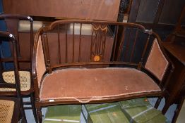 An Edwardian mahogany and inlaid salon settee, some damage and repair to shoulders