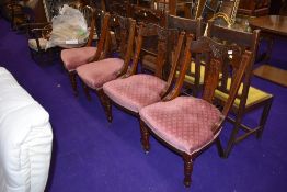 A set of four carved back dining chairs in mahogany with upholstered seats