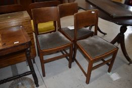 A set of four mid 20th Century oak dining chairs, having velvet upholstered seats and solid backs
