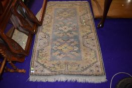 a small fire side rug in pastel colours