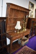 A traditional farm house yew and pine wood dresser having original meat hooks and delft rack