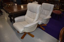 A pair of Stressless style cream leather easy chairs