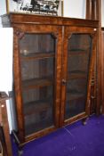 A flame veneered double fronted book case