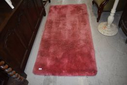 A vintage pink rug, deep shag pile, approx. 150cm x 80cm