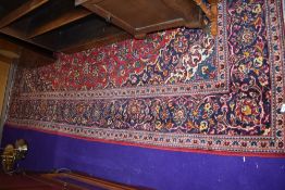 a large carpet square rug in red and dark blue grounds