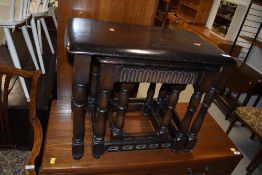 A nest of three priory style tables, dark stained