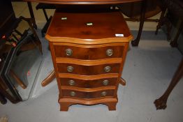 A reproduction yew wood, serpentine front 4 drawer dwarf chest, width approx. 41cm , with label