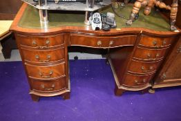 A traditional serpentine fronted mahogany desk by Reprodux Bevan Funnell