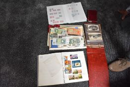 A collection of World Stamps, Covers, Postcards and GB Banknotes