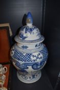 An early 20th century blue and white lidded jar of bulbous style, having band and pictorial