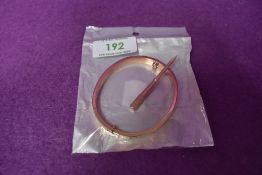 A Rose gold coloured copy love bangle bearing the name Cartier with screw driver