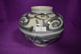 A Chinese Ming dynasty earthen ware vessel having a green and blue hue palette decorated with swirls