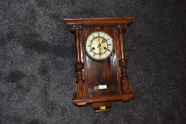 A wall mounted pendulum clock having enamel dial and mahogany styled case with chime