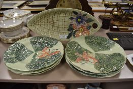 A plate in the shape of a leaf with hand painted floral design to end with embossed basket weft