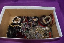 A box of costume jewellery including bangles, bracelets and chains