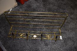 A Mid century brass coat rack with shelf.
