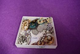 A small selection of costume brooches including diamante, coin etc