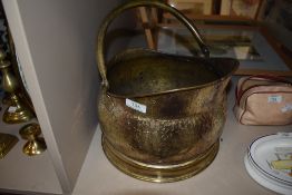 A brass coal bucket with handle.