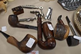 An assortment of vintage pipes having wooden bowls, an inlaid snuff box, a pen knife and more.