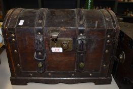A small wooden retro chest with handles to sides, straps and lock to front.