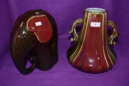 A ceramic elephant vase and similar heavy set squat vase in red and green glaze