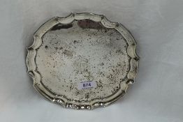 A silver card tray of plain form having monogram to centre, pie crust rim and quadrafoil scroll