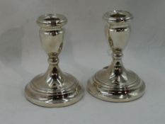 A pair of silver candle sticks of squat form on circular weighted bases, Birmingham 1971, Cooper