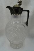 A cut glass claret jug of oval form having chequered decoration and plated handle and lid with