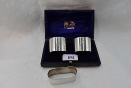 A cased pair of silver napkin rings of plain form bearing monogram A, Chester 1925, Barker Brothers,