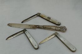 Two Edwardian folding fruit knives having HM silver blades and mother of pearl handles, a similar