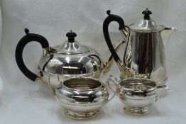 A four piece silver tea set of plain compressed circular and baluster form having banded waist,