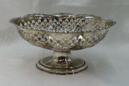 A silver table basket of oval form having pierced decoration and moulded rim on a pedestal foot,
