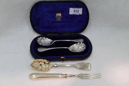 A cased pair of Victorian silver jam spoons having scalloped bowls and embossed terminals, London