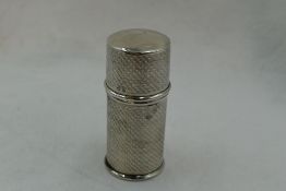 A silver cylindrical container having plastic liner, push on lid and chequered engine turned