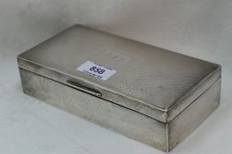 A silver cigarette case having engine turned decoration to lid with monogrammed cartouche and