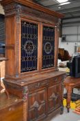 A Victorian oak bookcase having cupboard base, with lion mask carvings, upper section with