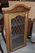 A modern oak corner cupboard with leaded effect glass