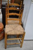 A pair of ladder back rush seated kitchen chairs