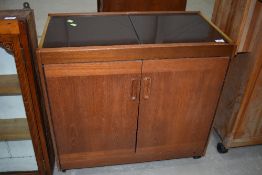 A vintage tea trolley in teak cabinet