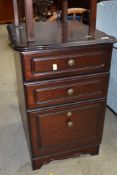 A modern mahogany effect three drawer bedside chest