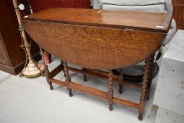 A traditional oak twist gate leg dining table, width approx. 107cm